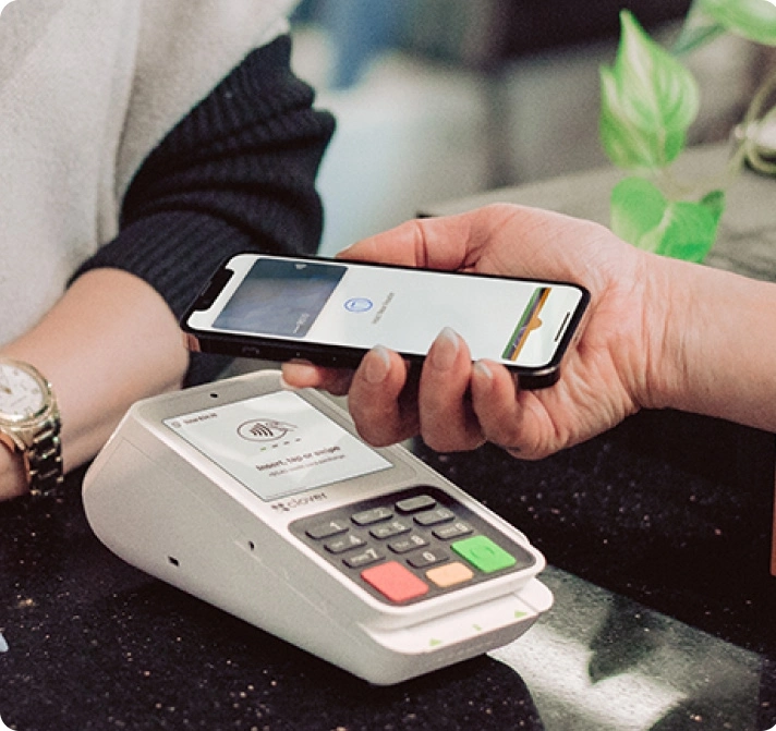 Two people using a Clover Compact on their mobile devices to make a credit card transaction