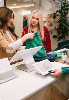Two women at a clothing store and using a Clover Duo