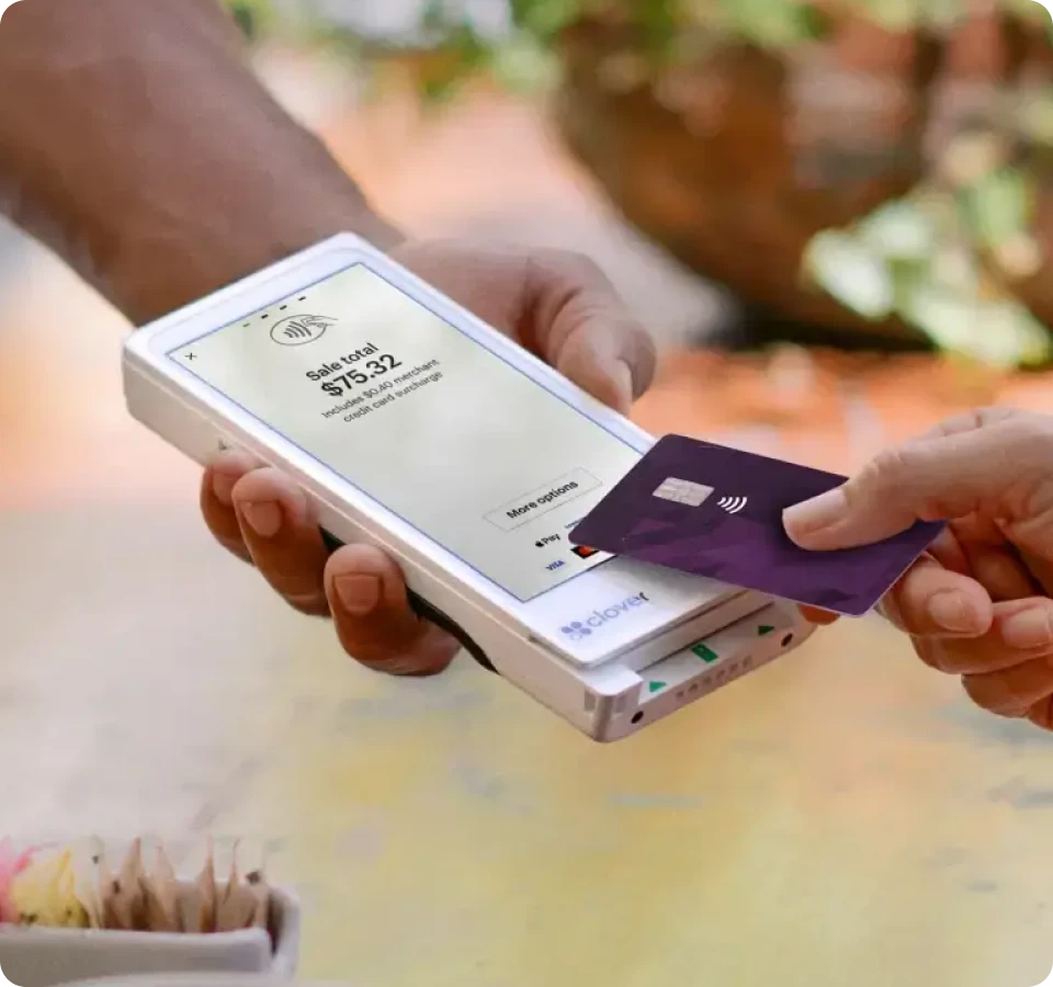 Two people using a Clover Flex Pocket on their mobile devices to make a credit card transaction