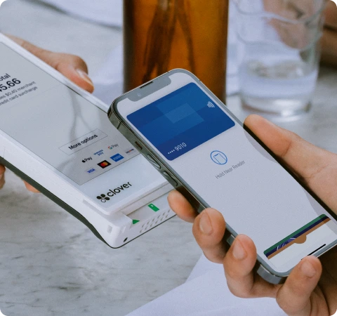 Two people using a Clover Flex on their mobile devices to make a credit card transaction