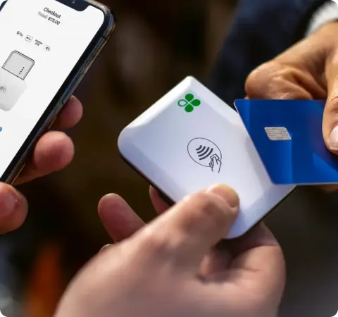 Two people using a Clover Go device to make a credit card transaction