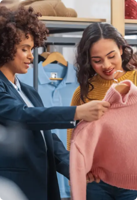 Two women looking at a sweater together