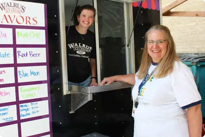 Two smiling women in front of Walrus Ice Cream, an Ice Cream shop that uses Clover Mini